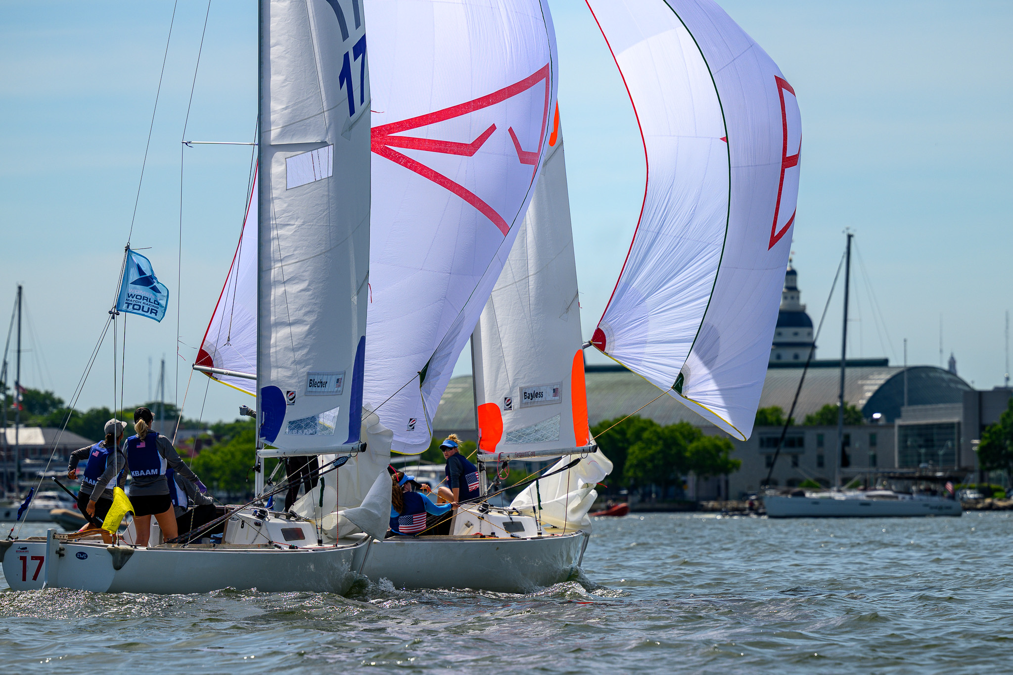 Fleet running downwind under colorful spinnakers